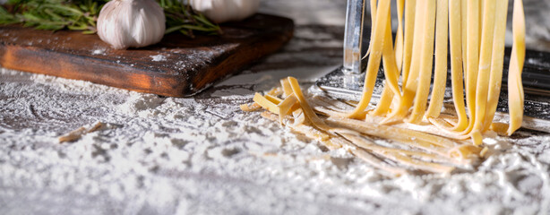 Fresh raw noodles made on home pasta machine on kitchen table low angle view