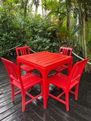 Obraz premium Red wooden table with chairs setting up on the wood black floors.
