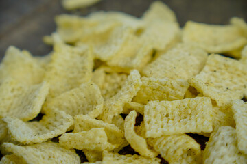 full screen view of hollow net chips with a sprinkling of fine spices on a wooden table. hollow net...