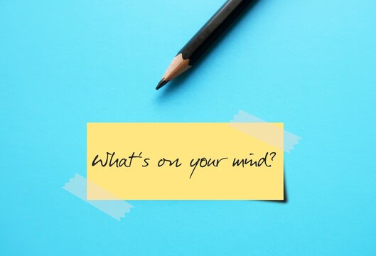 Stick Note on blue background with text written Whats on your mind? - WHAT'S ON YOUR MIND? -  a way of asking someone What are you thinking about? or What topic is occupying your mind right now?