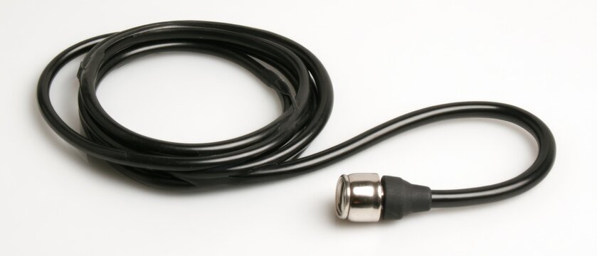 Coiled Black Cable with Connector on White Background Close Up Studio Shot Minimalist Style for Technology or Industrial Use
