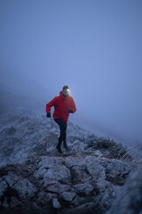 Balancing on the Mountain Trail at Dusk.A lone hiker balances on a rocky mountain trail during...