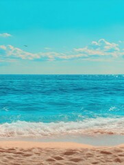 Ocean wave rolls onto sandy beach under blue sky with clouds above water horizon aerial view