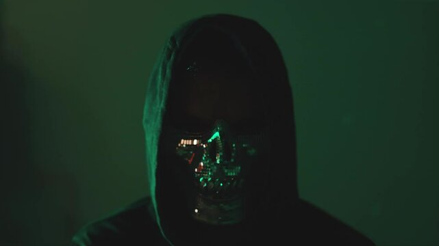 Hooded hacker Cyber attacker in mask and hoodie watching camera
