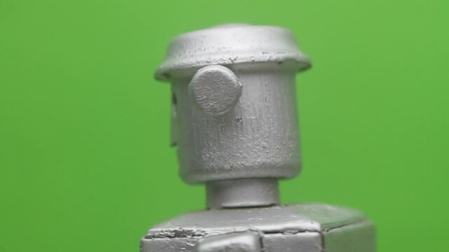 Retro robot head spinning with green background 