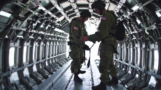 Soldiers methodically examine aircraft interior, professional approach emphasizes responsibility as soldiers verify essential gear for critical aerial mission safety.