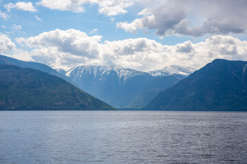 Early morning landscape of Teletskoye lake in Altai Russia. Calm water, soft light and serene mountain atmosphere near Artybash