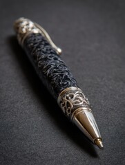 Ornate silver and black ballpoint pen close up studio shot on dark background writing instrument office supply
