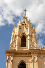 Fototapeta premium Iglesia del Sagrado Corazon in Malaga. Architectural detail of a historic church tower featuring intricate design elements and a dramatic sky backdrop