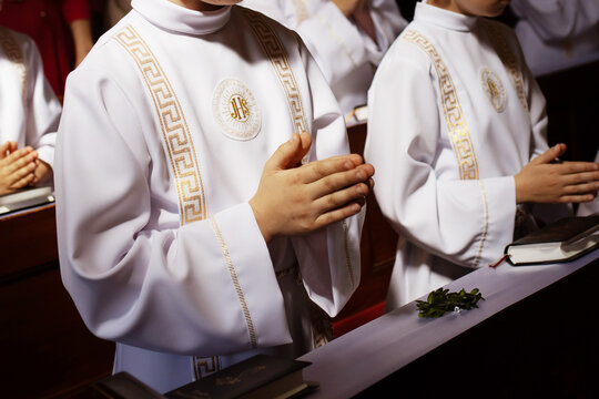 Young child receiving the Eucharist for the first time during a Catholic Mass. First Holy Communion marks a key moment of faith, purity, and tradition in Polish religious life.