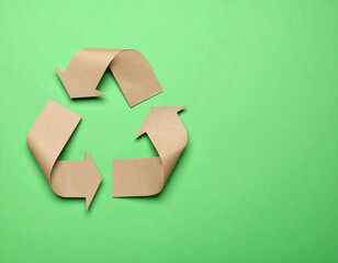 Recycling symbol cut out of kraft paper on vibrant green background, creating fresh and eco friendly feel
