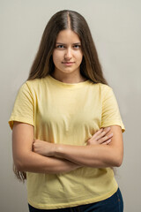 Obraz premium Confident young woman standing with folded arms showing natural skin texture in portrait
