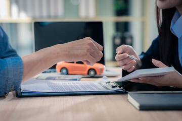 Fototapeta premium Car dealer and customer are signing loan, insurance and investment contract. Car sales concept. Close up.