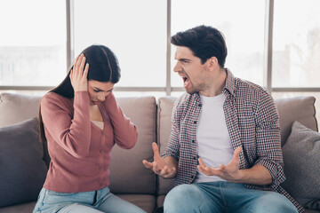 Upset young couple arguing in the living room, highlighting the struggle of relationships and...