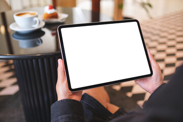 Mockup image of a woman holding digital tablet with blank white desktop screen in cafe