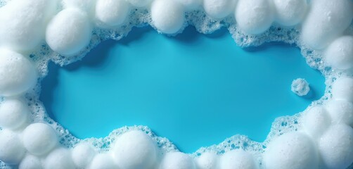 Close-up shot of white soap foam with blue water background. Bubbles surround frame. Pure, clean concept. Detergent, washing, cleaning products concept.