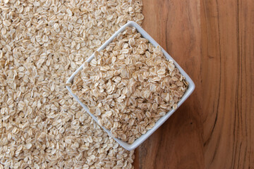 Uncooked oat flakes in plate on the table.