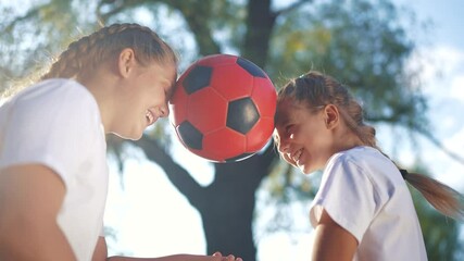 Children playing ball in the park sun glare cheerfully. Child kid game concept. Group of girls and kids playing soccer together. Group of children and girls play soccer together in lifestyle a team. - Powered by Adobe
