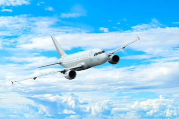 Airplane flying in the sky among clouds, white commercial airplane in the flight