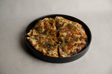 Chicken Tikka Kulcha Stuffed with juicy chicken tikka Served on Black Plate – Overhead Shot on Grey Background