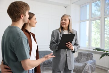 Smiling real estate agent working with couple at home