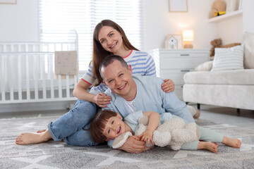 Fototapeta premium Cute little boy and his parents at home. Lovely family
