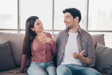 Happy young couple sharing a lively moment together in their cozy home, enjoying each other's company on a sunny day.