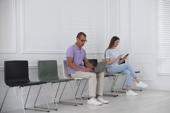 Man and woman waiting for appointment indoors