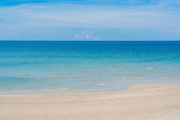 Fototapeta premium Beautiful nature of the sea in summer, with sunlight, sandy beaches, and sparkling water contrasting against the blue sky.