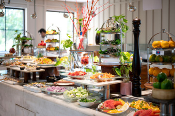 Fresh and colorful salad counter at a hotel buffet featuring a variety of vegetables, toppings, and dressings, neatly arranged for a healthy dining experience.


