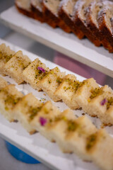 Close-up of assorted fruit cakes beautifully arranged on a dessert buffet counter, showcasing vibrant toppings and elegant presentation for a hotel or restaurant dining setup.
