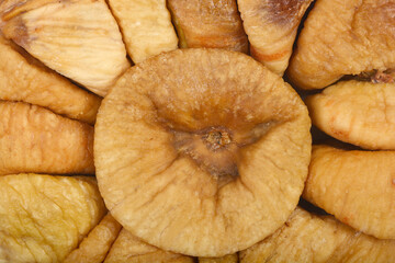 A tight close-up shows the intricate texture of a dried fig, surrounded by other figs forming a circular pattern