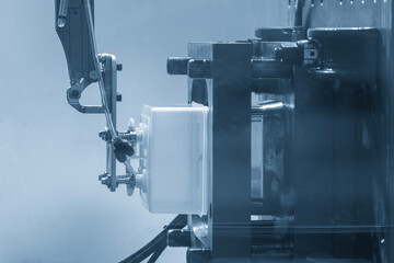 Close up scene material handling process the food container by robotic system from injection machine.