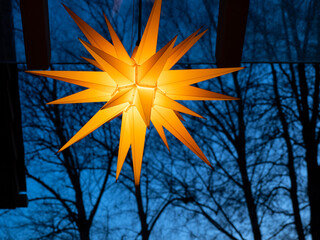 Herrnhuter Stern - Moravian Star - Stern leuchtet goldgelb in der Abenddämmerung