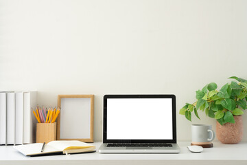 Modern workspace with blank laptop display ready for mockup use, surrounded by practical and aesthetic elements.