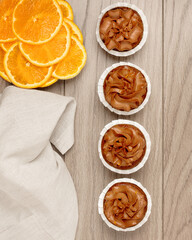 four chocolate cupcakes in a row, oranges, top view