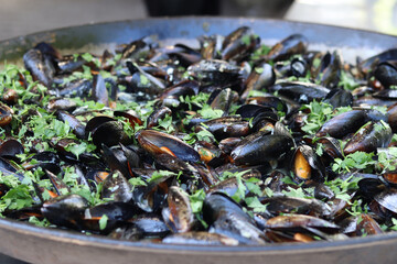Mussels in a cauldron. Food court. Street food. Mussels cooked in shell. Mussels cooked in sauce, cauldron. Cooking a seafood dish