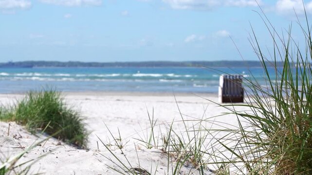 white sand beach on blurred baltic sea beackground with blue slow motion water waves, idyllic natural background with copy space for product display