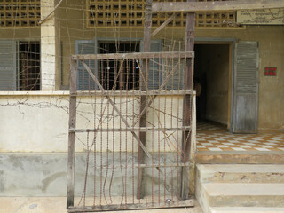 A metal gate with barbed wire at tuol sleng prison in Cambodia
