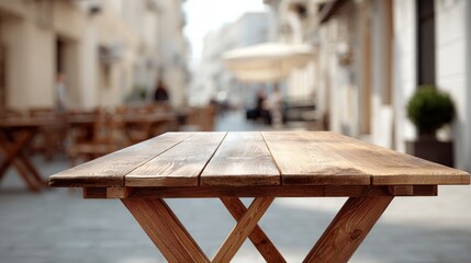 Wooden table is sitting on a sidewalk in front of a building. The table is empty and the sidewalk is empty