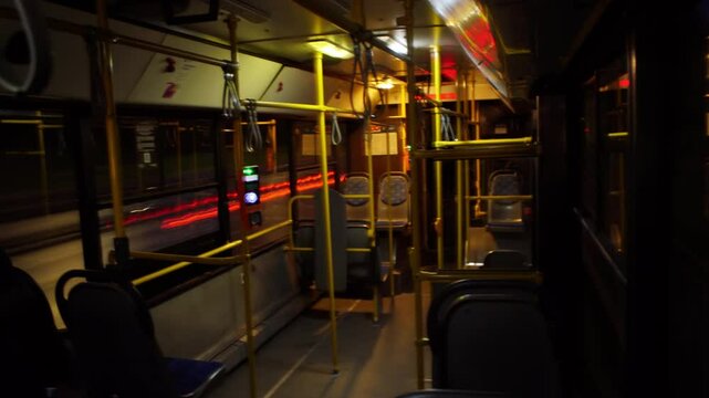 POV timelapse from inside a city bus at dusk; window view captures light trails, motion-blurred people and traffic, showcasing fast-paced urban commute vibe.