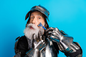 Humorous depiction of a bearded man in medieval knight armor shaving against a vivid blue background