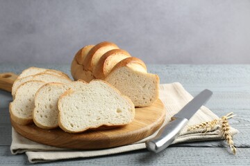 Sliced bread and knife on grey wooden table