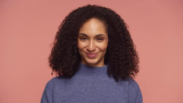 Smiling woman nodding head in approval on pink background