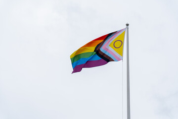 Pride Flag Displayed Proudly Against Pale Sky on Bright Day