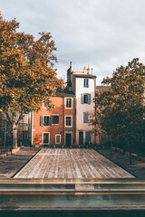 little square and pastel buildings in the streets of nimes, south france
