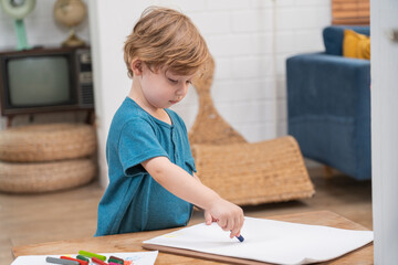 Happy moment little cute boy creating and water color painting activity with paint brushes on frame canvas at living room. Kids activity. Child physical. Emotional. Cognitive development concept.	