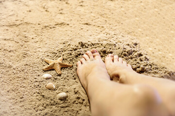 Young Woman Relaxing on the Beach. Close up of Female Feet on Sand. Beach background and copy space.