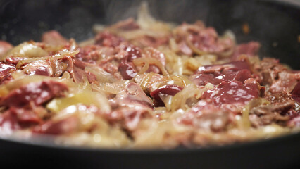 Frying Chicken Liver with Onions in Hot Skillet.
