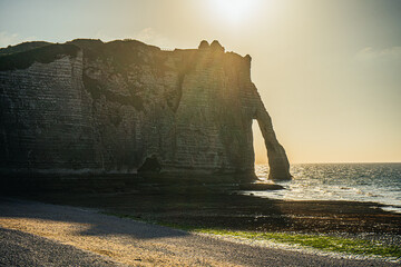 Zachód słońca nad Kanałem La Manche w Etretat, Normandia we Francji. Białe klify z wapienia i kamieniste plaże. © Franciszek